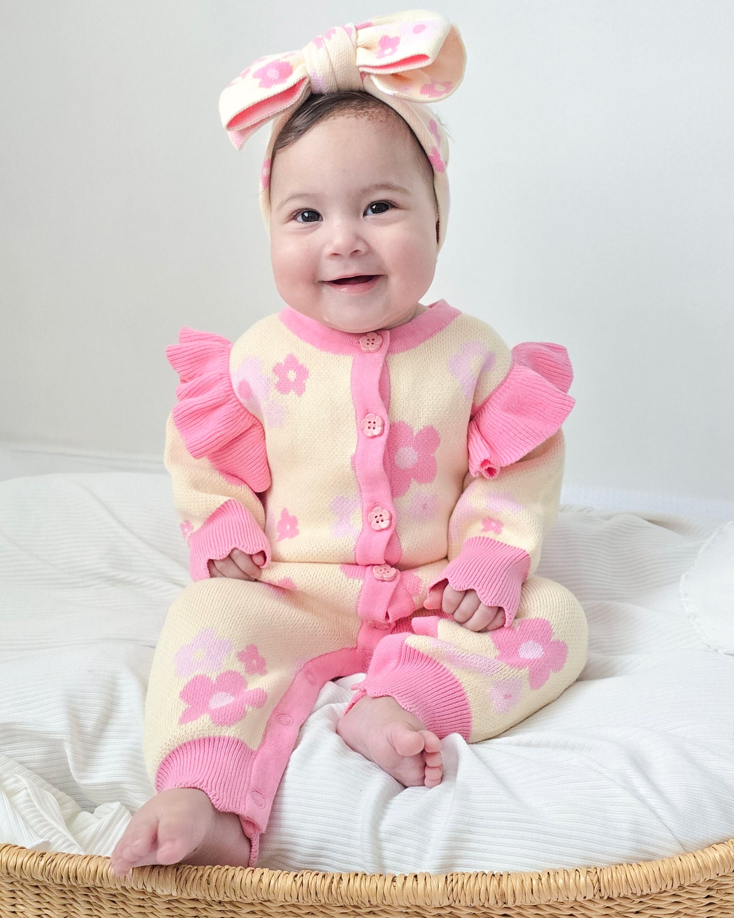 Baby girl wearing the Buttercup Princess floral knit set in cream and pink, featuring flower details and ruffle sleeves, by Little Violet Threads.