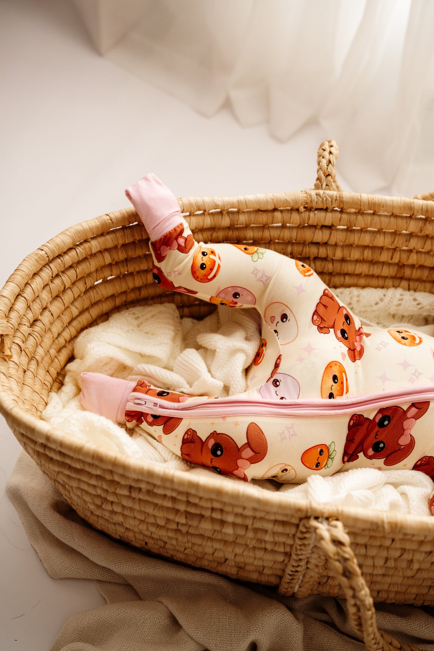 Close up of Pink Easter Bunny bamboo zip romper in woven bassinet