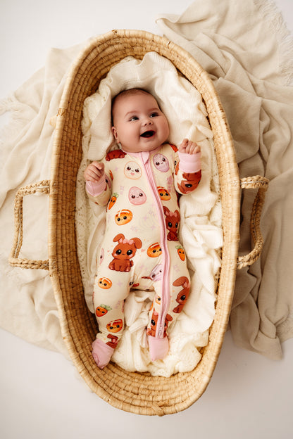 Baby wearing Pink Easter Bunny bamboo zip romper lying in woven bassinet