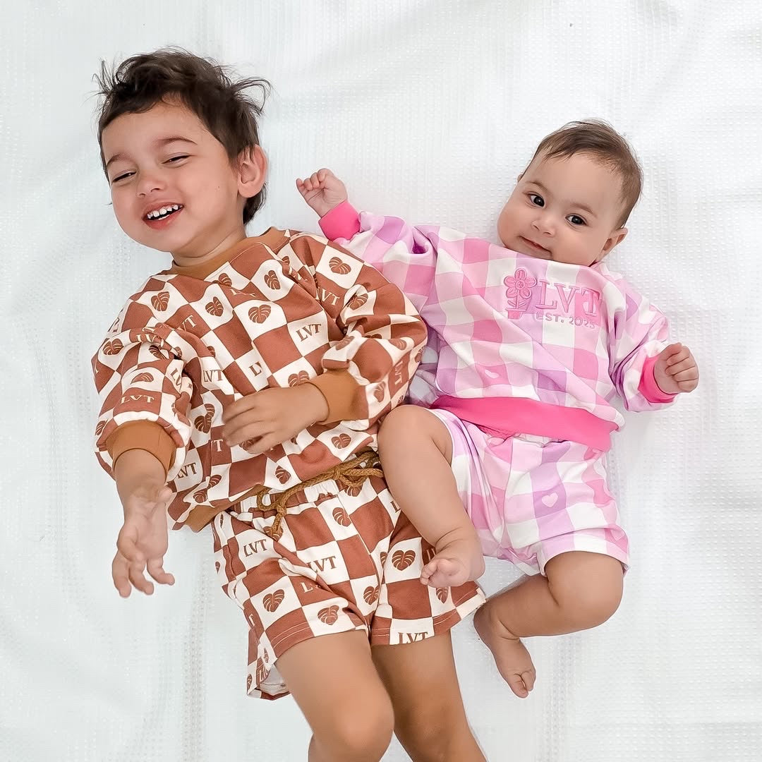 Two children wearing matching pajama sets on a white background