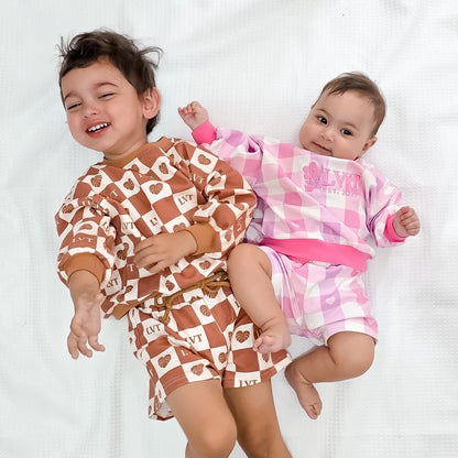 Two children wearing matching pajama sets on a white background