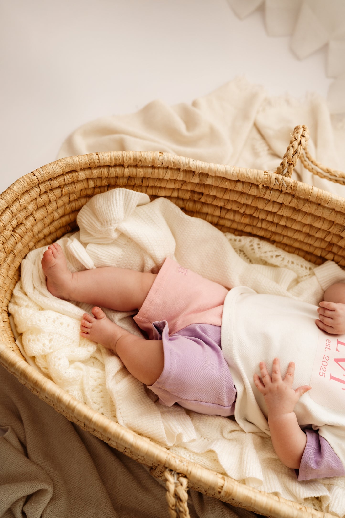 Baby lying in bassinet wearing Pastel Dreams cotton two piece set