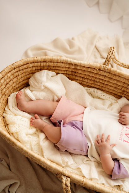 Baby lying in bassinet wearing Pastel Dreams cotton two piece set