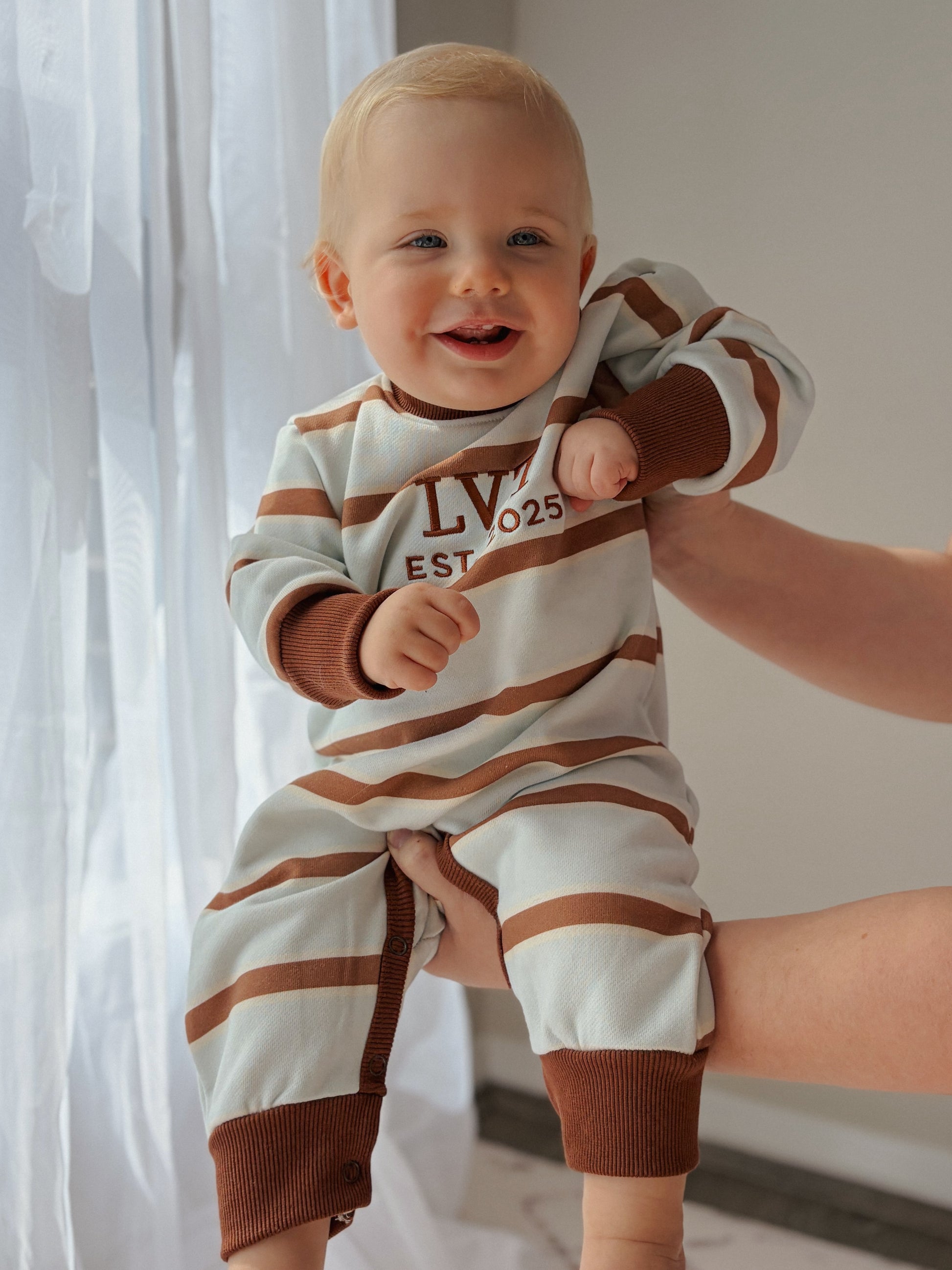 Bubblegum French Terry baby romper by Little Violet Threads in blue, cream and chocolate stripes with embroidered logo.