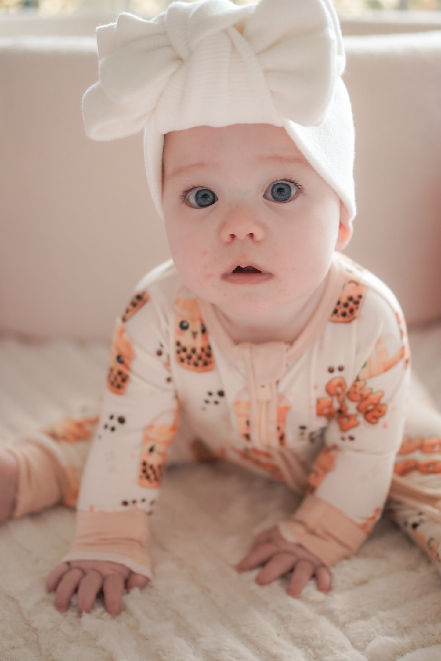 baby wearing little violet threads bubble tea baby bamboo zippy romper crawling with white bow headwrap