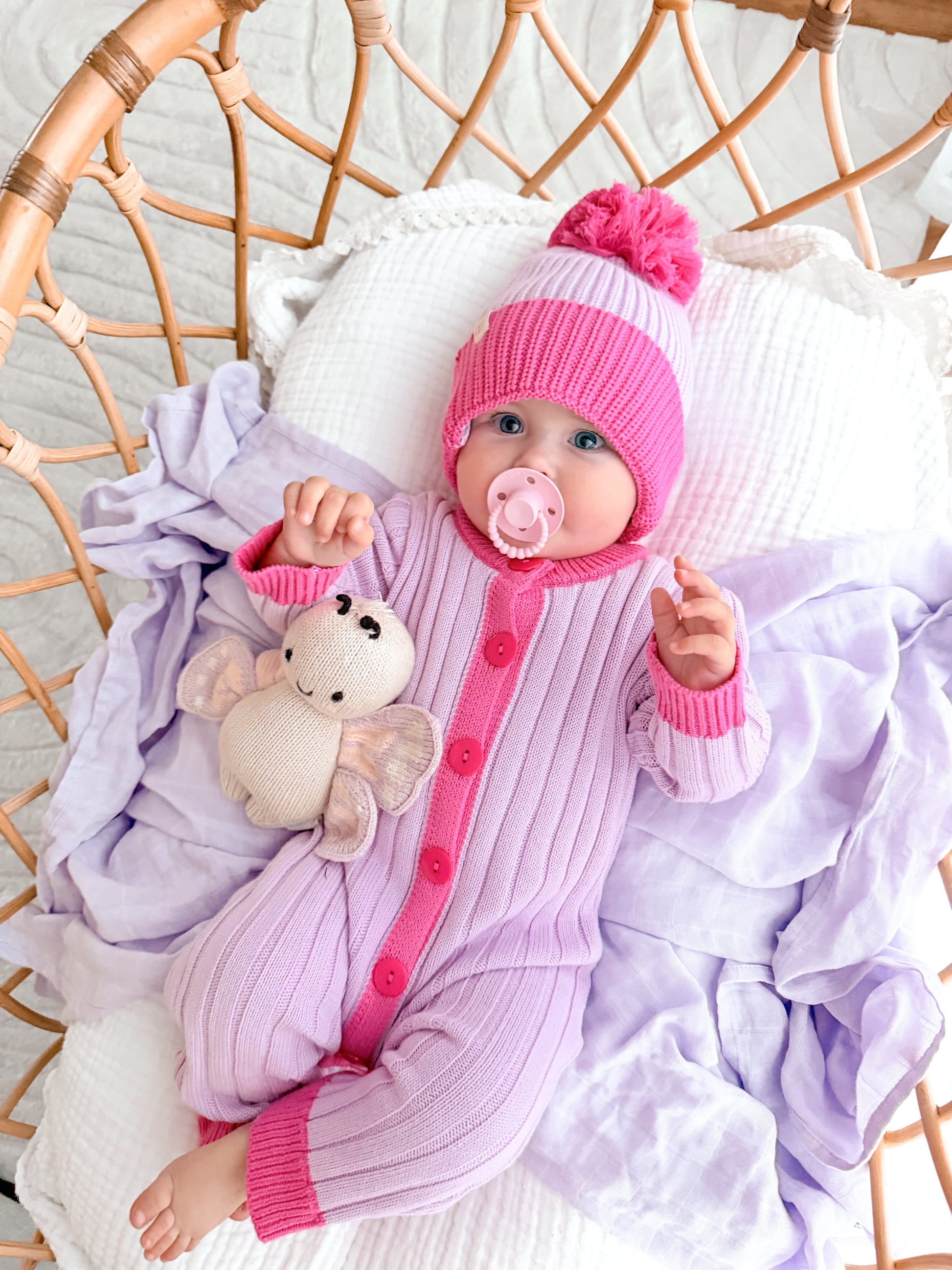 Baby wearing the La Dolce Lollie Beanie with matching purple and pink cotton knit romper