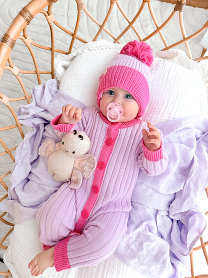 Baby wearing the La Dolce Lollie Beanie with matching purple and pink cotton knit romper