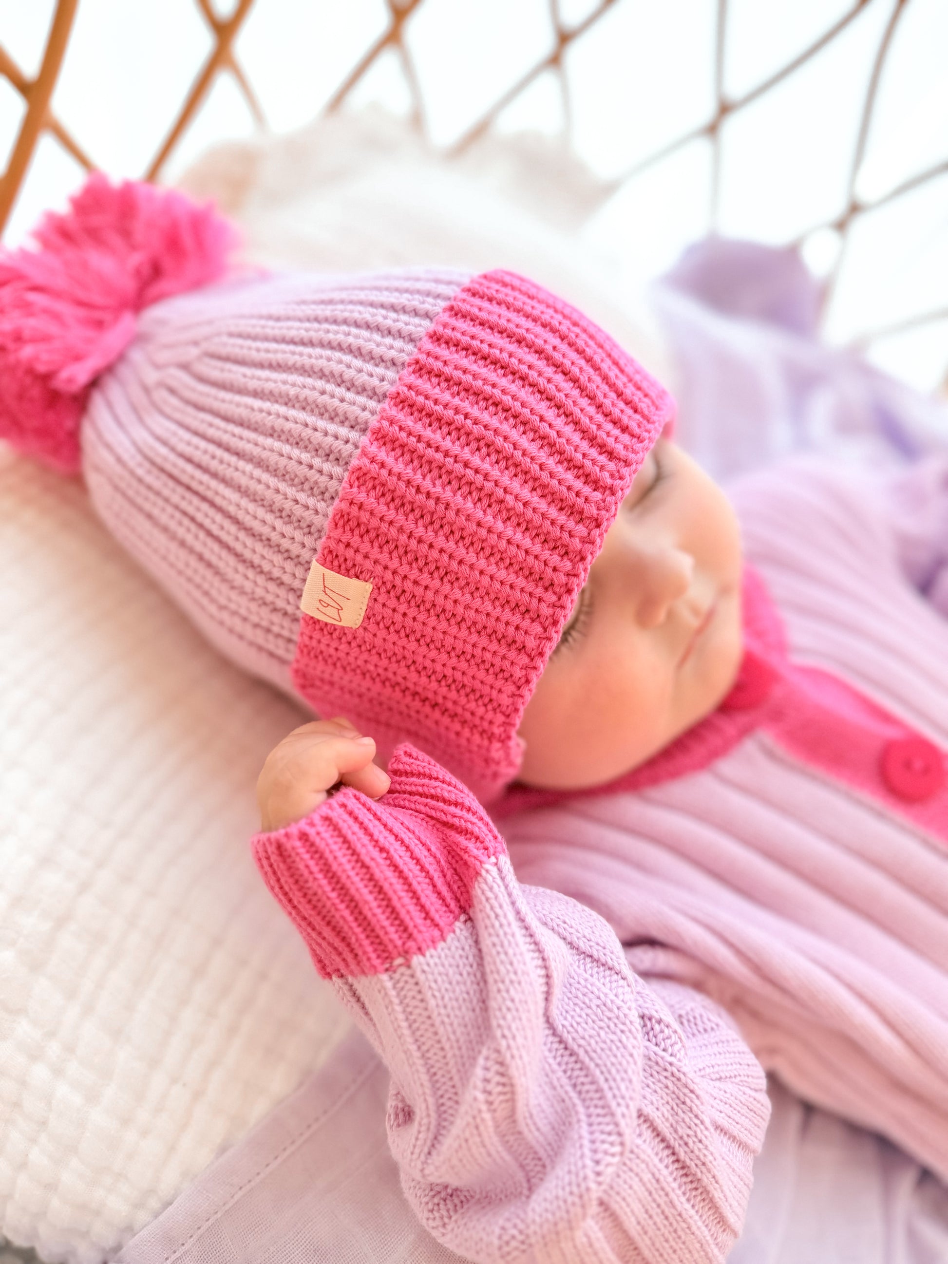 Close-up of the La Dolce Lollie Beanie in pink and purple 100% cotton knit with fluffy pom