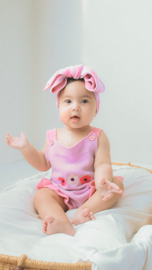 Baby girl wearing the La Dolce Lollie Blossom Romper in soft purple cotton knit with floral embroidery
