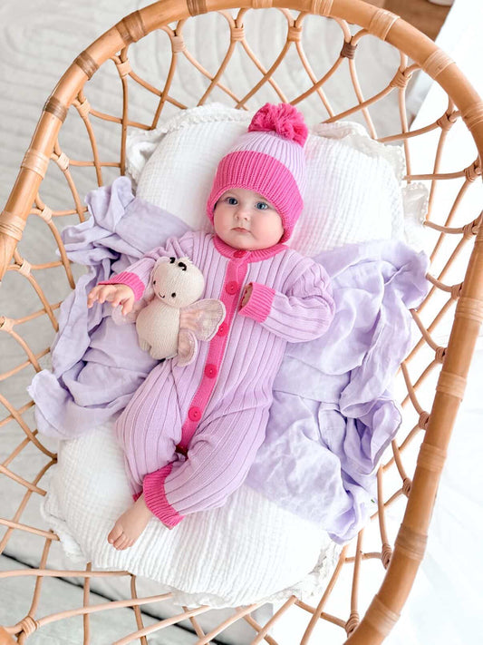 Baby wearing the La Dolce Lollie Dream Romper with matching pink and purple cotton knit beanie
