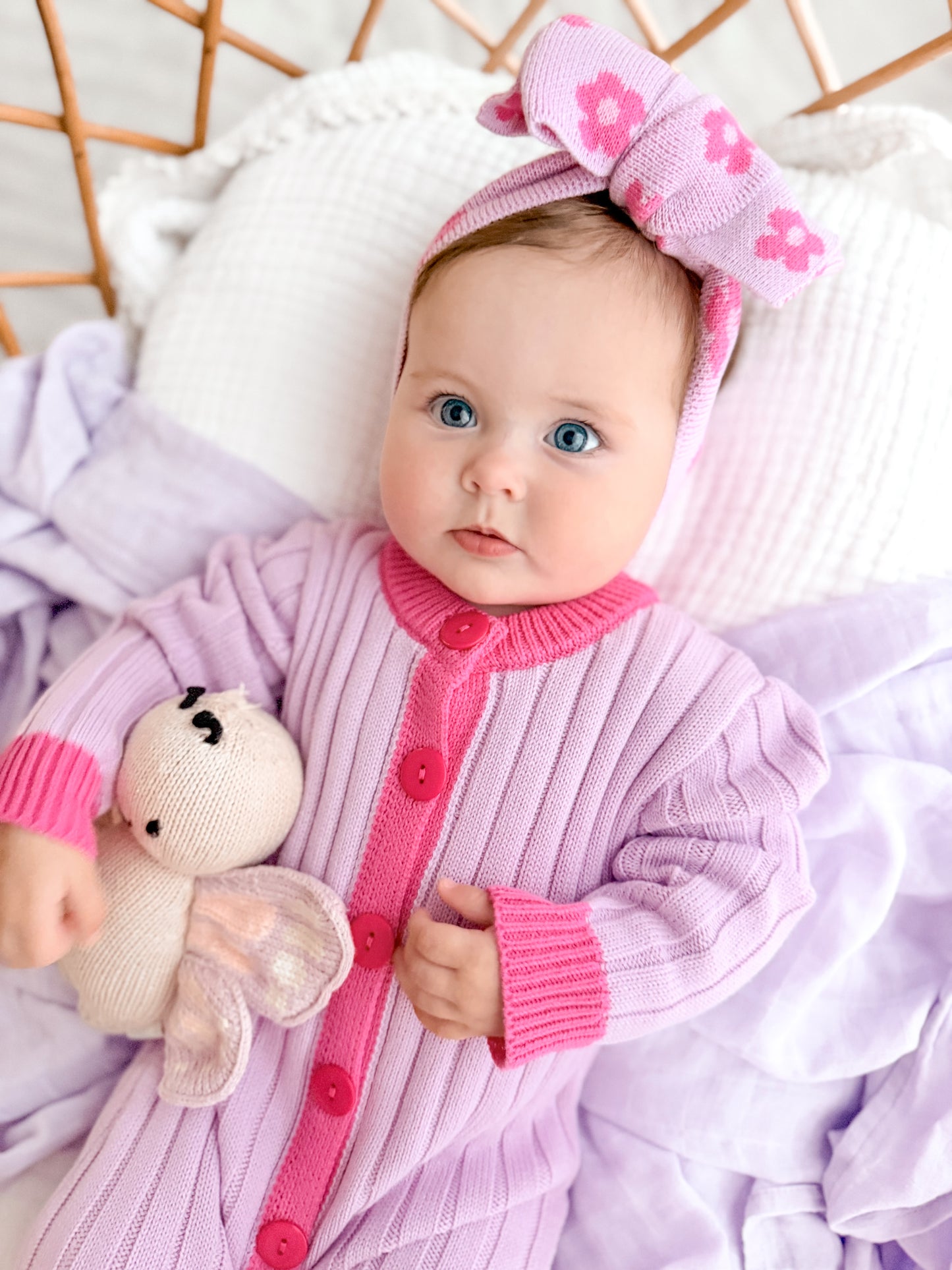 Baby girl wearing the La Dolce Lollie Dream Romper in purple and pink cotton knit with matching oversized bow