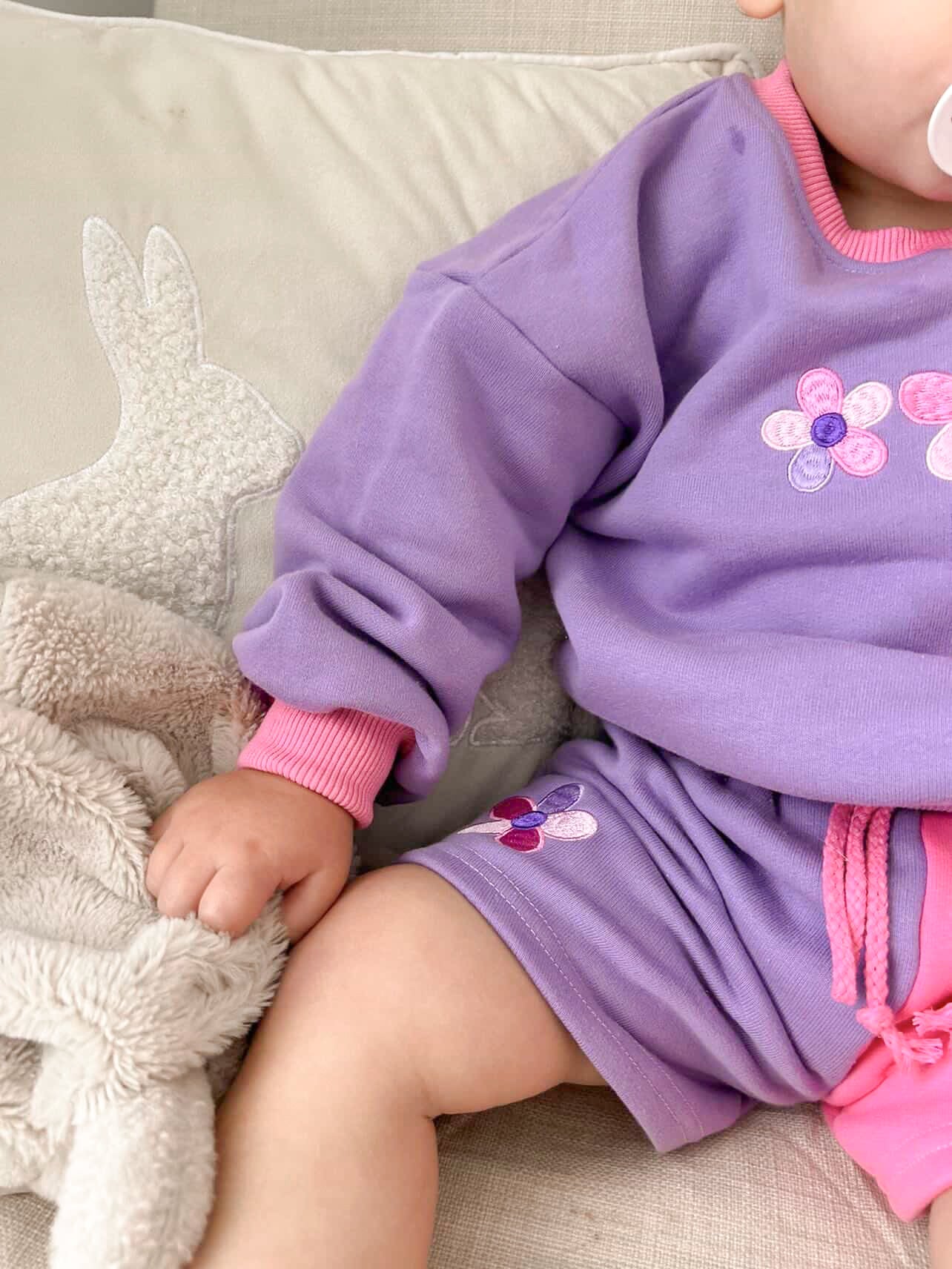 Close-up detail of the Little Violet Threads La Dolce Lollie pink and purple jumper set featuring embroidered floral details and colour block design
