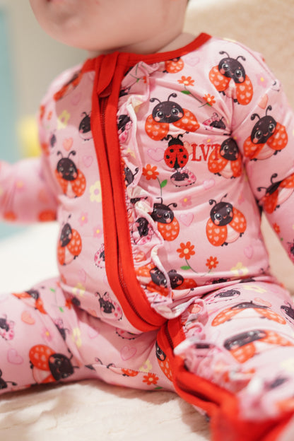 close up detail of little violet threads lady bug baby bamboo zippy romper with frill zipper
