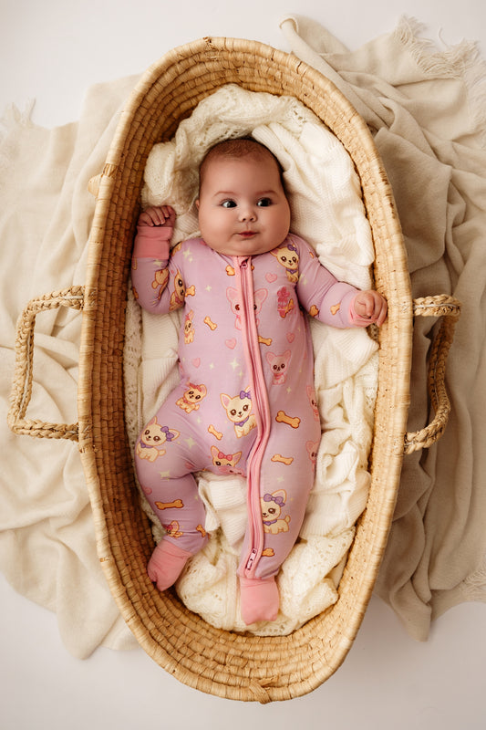 Baby wearing pastel Chiwidreams bamboo zip romper lying in woven bassinet – Little Violet Threads