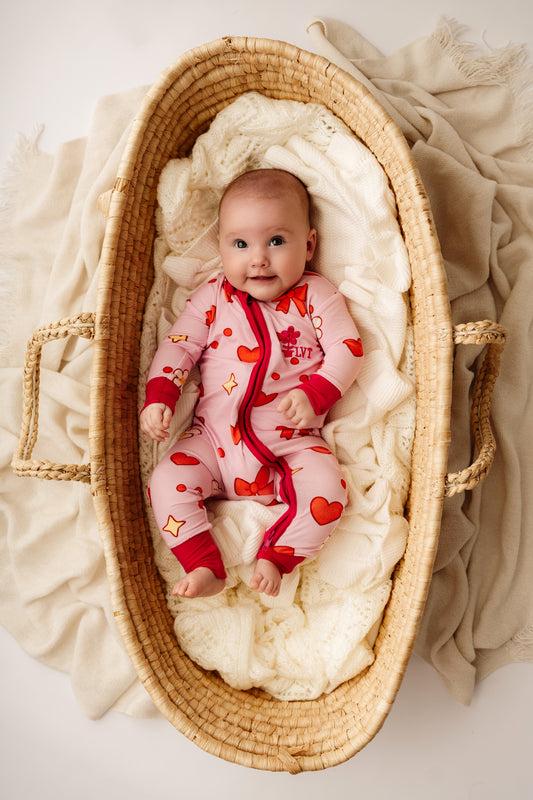 Close lifestyle view of baby wearing Valentina heart bamboo zip romper – Little Violet Threads