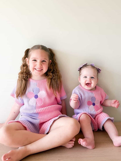 Two girls wearing matching Little Violet Threads Petal Knit Sets from the La Dolce Lollie collection in pink and purple floral knit design