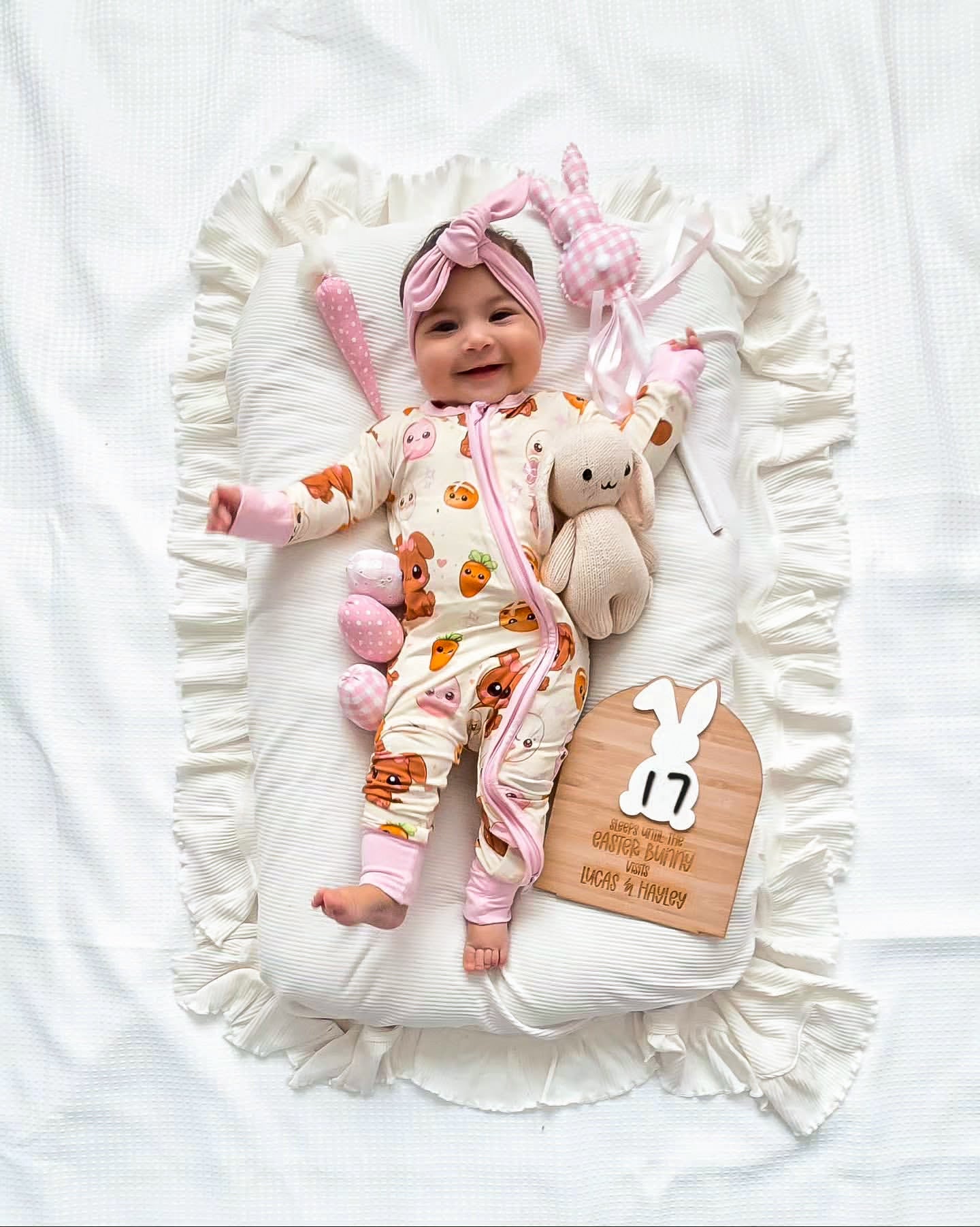 Baby wearing Pink Bunny bamboo baby zippy romper lying on blanket