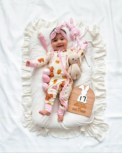 Baby wearing Pink Bunny bamboo baby zippy romper lying on blanket
