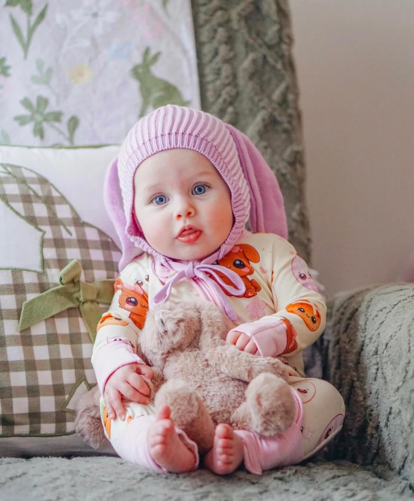 Baby wearing Pink Bunny bamboo baby zippy romper sitting with teddy bear