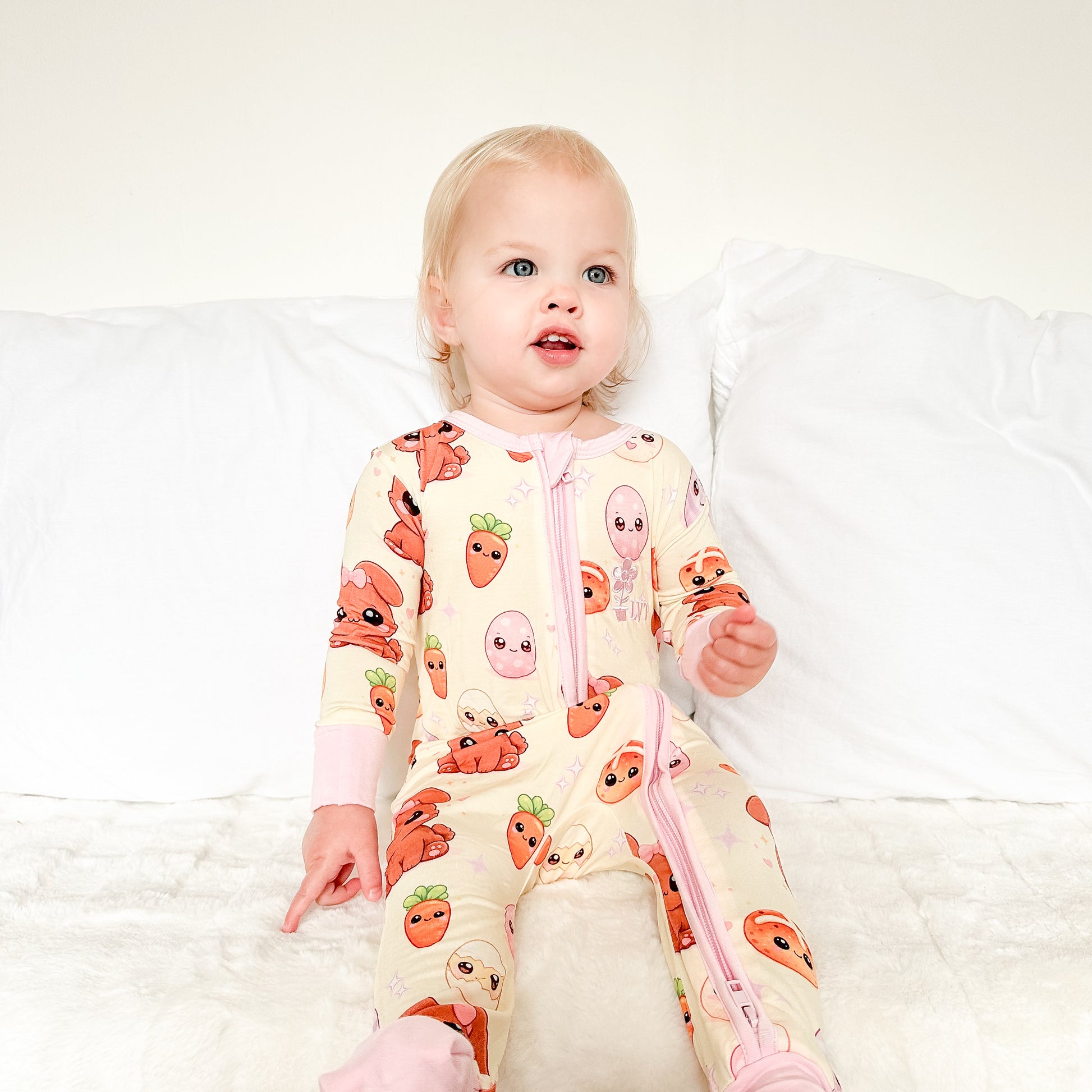 Toddler wearing Pink Bunny bamboo baby zippy romper sitting indoors