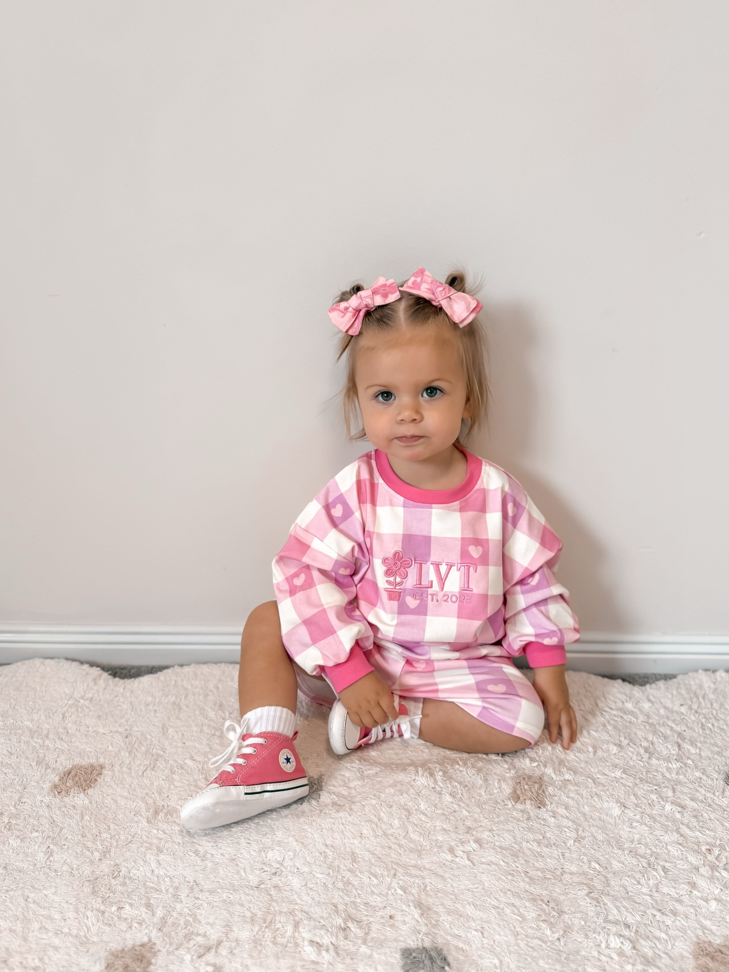 Baby girl wearing Little Violet Threads Pink Sugar Lounge Set in pink gingham, oversized jumper and matching shorts