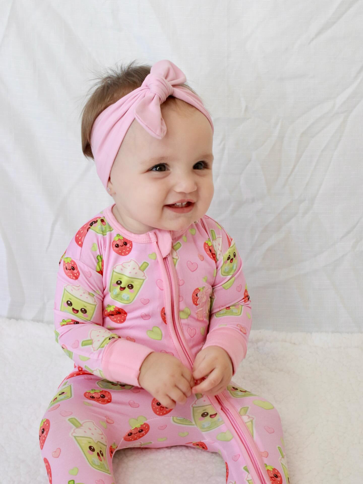 Baby wearing Strawberry Matcha bamboo baby zippy romper sitting and smiling