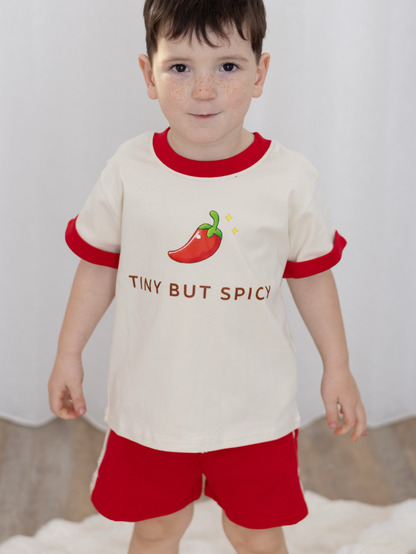Child wearing our Tiny But Spicy matching kids set featuring oversized tee with chilli graphic and red relaxed shorts