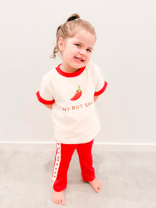 toddler wearing little violet threads tiny but spicy kids tee and red flare pants set